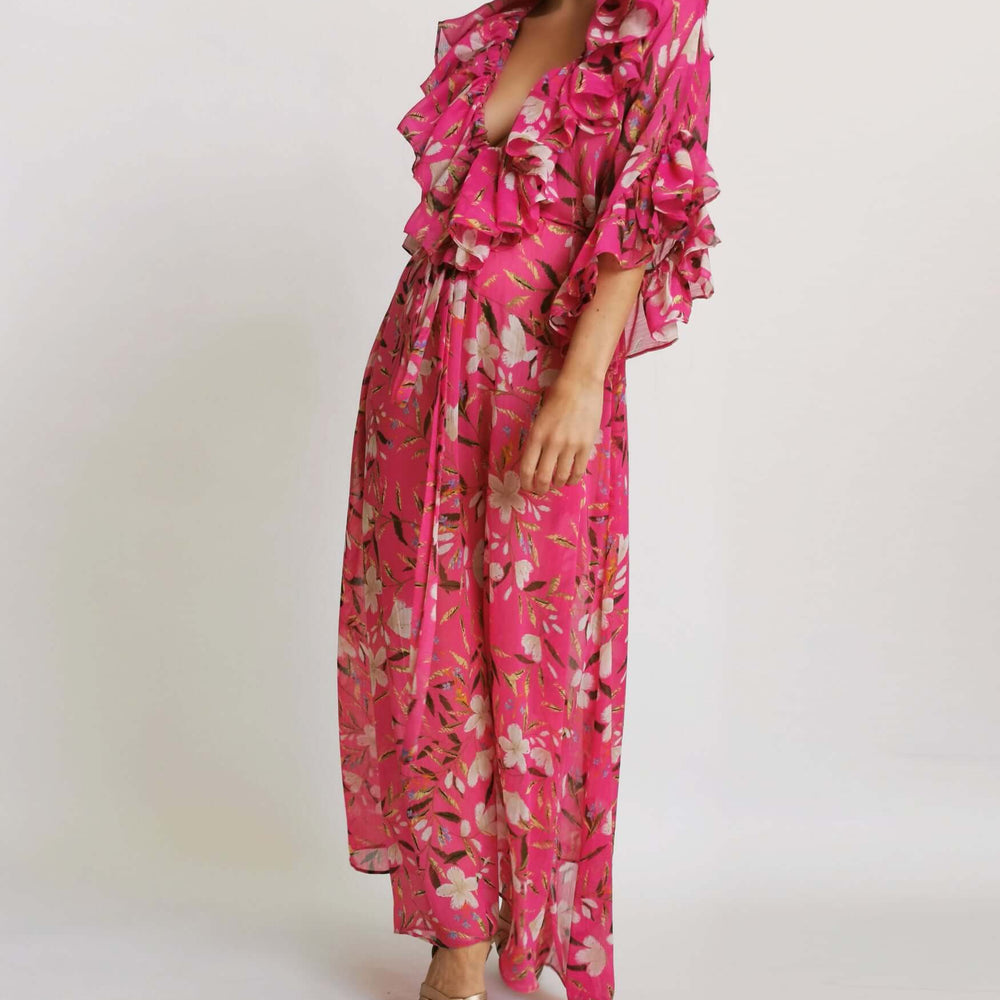  A model in a pink floral print dress posing for a photoshoot.
