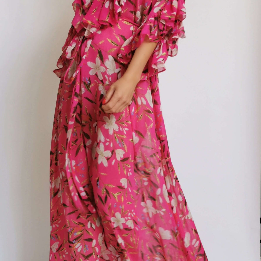 Pink floral print dress worn by a model in a stylish pose.