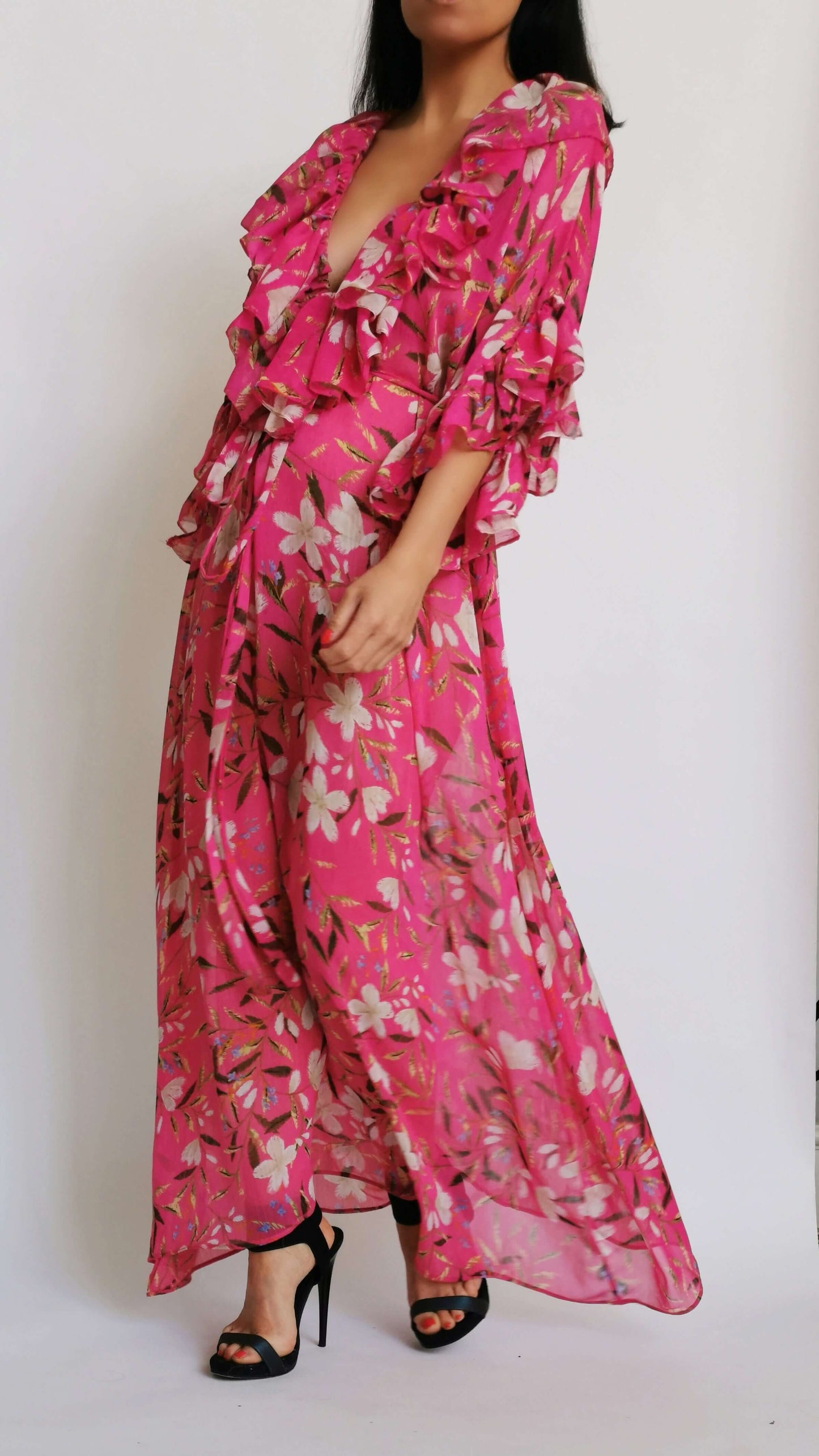 Pink floral print dress worn by a model in a stylish pose.